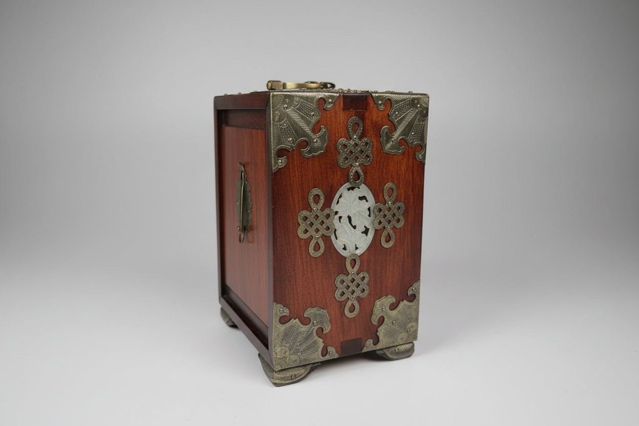Decorative wooden box with metal embellishments on a dark surface