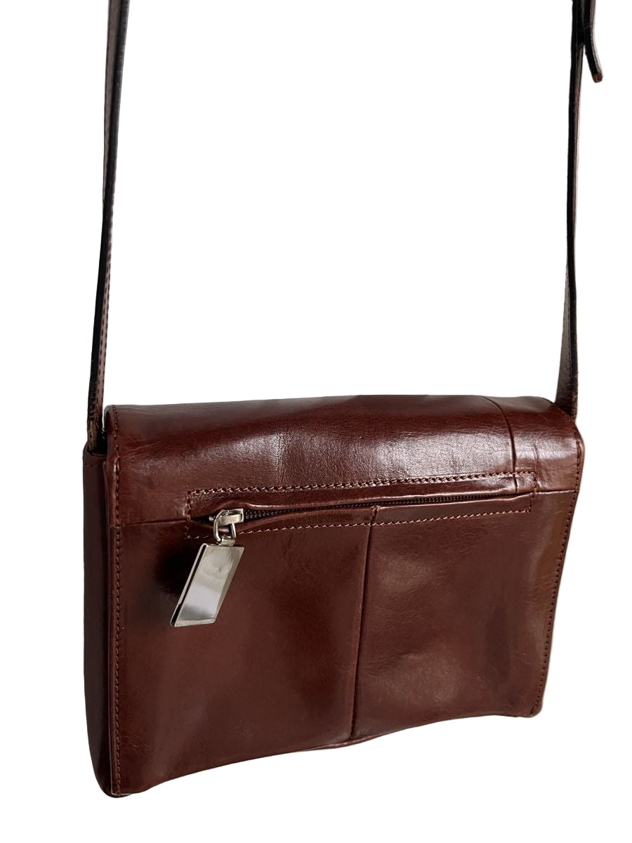 Brown leather handbag with a silver zipper on a light background