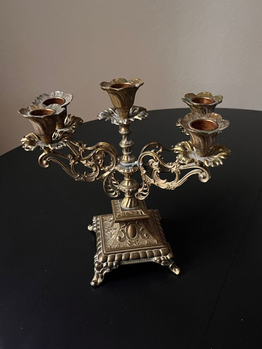 Silver candelabra on a black surface with a neutral background